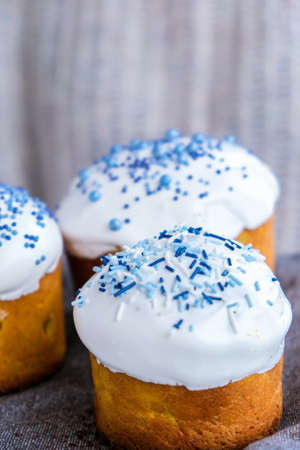 The cook Hands hold Easter cake with white topping and blue sprinkles. Woman holding traditional...