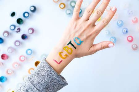 Rainbow LGBTQ flag painted on hand. Support for lgbt community. Honor of pride month. Connecting...
