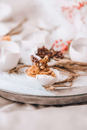 Easter DIY. Do it yourself. Trendy Easter decorations. Cracked organic eggs with dry grass and dry...