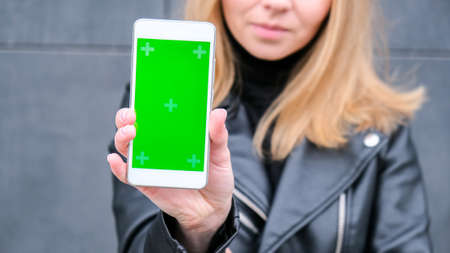 Female hands using mobile phone with green screen. Chroma key. Mobile app on Shopping Mall. People...