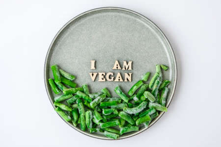 I AM VEGAN text in plate. Veganism, vegetarian healthy lifestyle green beans. Healthy eating vegan. Wooden lettersの写真素材
