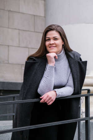 Portrait of young smiling caucasian brunette woman. Businesswoman outdoors in business downtown....