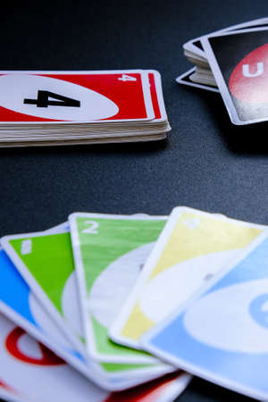 Kiev, Ukraine - 03/10/2021 Playing cards UNO on black Table games. Pastime. Board games. Stay home leisure activity for kids family. Pandemicのeditorial素材