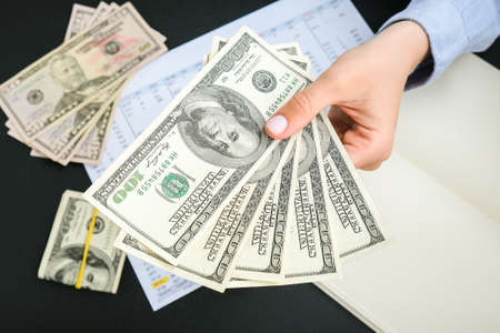 Business Woman Displaying a Spread of Cash US dollars. Close-up.