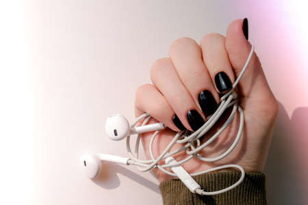 Black nails manicure. Minimal flat lay nature. Female hand. Creative idea. Self care Skin care