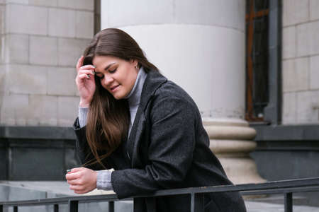 Portrait of young smiling caucasian brunette woman. Businesswoman outdoors in business downtown....