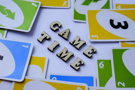 Kiev, Ukraine - 10.03.2021 Text Game TIME. Frame of playing cards UNO. Table games. Pastime. Wooden letters. Board games. Stay home leisure activity for kids.のeditorial素材
