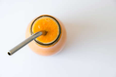 Seasonal pumpkin carrot smoothie drink detox with eco metal drinking straw. Glass bottle of orange smoothie or juice. Clean eating, weight loss, healthy dieting food concept. Fruit vegetable drink fitnessの写真素材