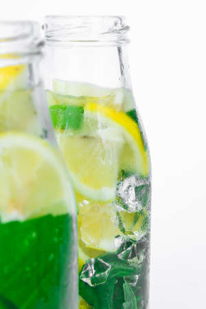 Mojito refreshing cocktail, alcohol drink. Lemonade with lemon and mint leaves on light background. Ice cubes. Summer refreshing detox drinks. Clean eating, healthy lifestyle concept, Diet. Nutrition.の写真素材