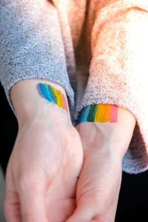 Rainbow LGBTQ flag painted on hand. Support for lgbt community. Honor of pride month. Connecting...