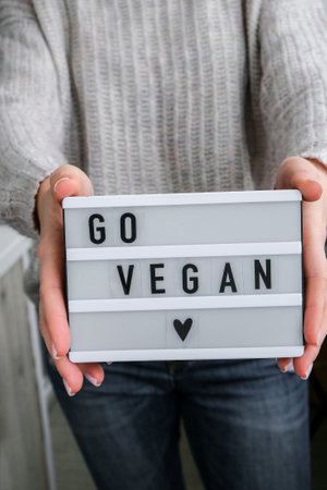 Lightbox with text GO VEGAN in female hands. Veganism, vegetarian healthy lifestyle. Healthy eating...