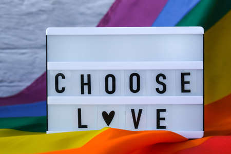 Rainbow flag with lightbox and text CHOOSE LOVE. Rainbow lgbtq flag made from silk material. Symbol of LGBTQ pride month. Equal rights. Peace and freedomの写真素材
