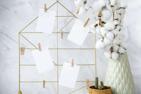 Cards and posters mock ups on grid board. Copy space. Feminine hipster office table decoration. Home office desktop. Freelance bloggers workplaceの写真素材