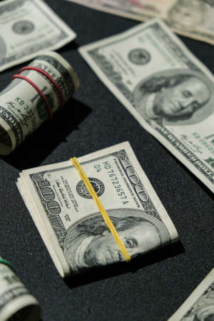 US dollars bundle close up isolated on dollar background. Paper denominations of dollars cash rolls with rubber bands.の写真素材