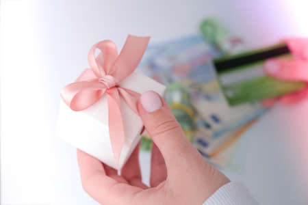Close up view of female using online banking application on smartphone and holding debit credit card...