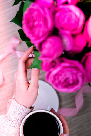 Cup of coffee and pink roses. Holiday concept, bouquet of roses for a birthday, bouquet of flowers...