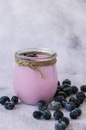 Bowl with yogurt and blueberries on table. Blueberry yogurt with fresh blueberries. Healthy breakfast. Super food healthy eating vegetarian vegan food. Dieting nutritionの写真素材