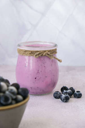 Blueberry smoothie topped with blueberries. A glass of breakfast protein smoothie drink made from pureed raw blueberries, banana, milk, yogurt, and cottage cheese. Vegetarian vegan foodの写真素材