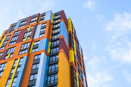 Modern building angle and windows. Multistory new multicolored apartment building. Stylish living block of flats. Parts of the facades of modern houses. Bright juicy colors in the construction of buildings.の写真素材
