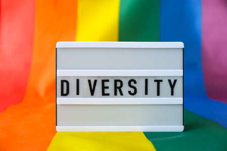 Rainbow flag with lightbox and text DIVERSITY. Rainbow lgbtq flag made from silk material. Symbol of LGBTQ pride month. Equal rights. Peace and freedom. Support LGBTQ communityの写真素材