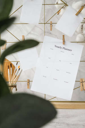 YEARLY PLANNER Cards and posters mock ups on grid board. Copy space. Home office desktop. Freelance bloggers workplace. Brushes and palette tools Creativeの写真素材