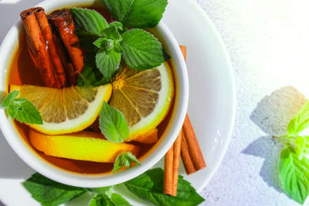 Black and green tea with lemon, cinnamon sticks and mint leaves. Hot drink. Healthy melissa tea...
