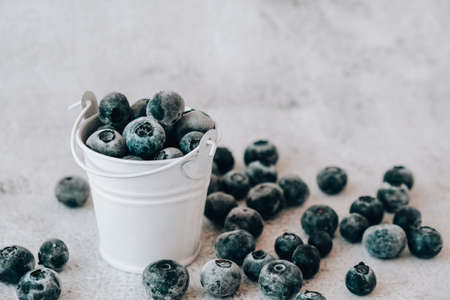 Frozen Blueberries in small Bucket on concrete background. Healthy organic seasonal fruit background. Organic food. Harvesting, Preparing food for winter. Superfood. Good vision. Keep eyes healthyの写真素材
