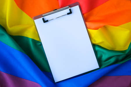 Rainbow flag with empty paper note copy space. Rainbow lgbtq flag made from silk material. Symbol of LGBTQ pride month. Equal rights. Peace and freedom. Support LGBTQ communityの写真素材