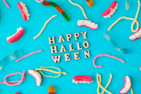 Halloween concept. Halloween party decorations with words Happy Halloween, sweets, top view flat lay on blue background. Greeting cardの写真素材