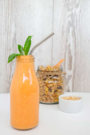 Seasonal pumpkin carrot smoothie drink detox with eco metal drinking straw Glass jar granola muesli oatmeal breakfast. Orange smoothie. Clean eating, weight loss, healthy dieting food concept Fruit vegetable drink fitnessの写真素材