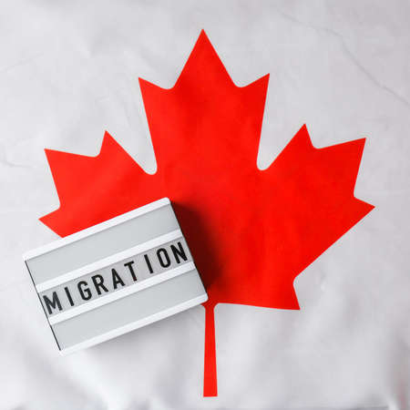 The National Flag of Canada. Lightbox with text MIGRATION Canadian Flag or the Maple Leaf. Patriotism. International relations concept. Independence day. Immigrationの写真素材
