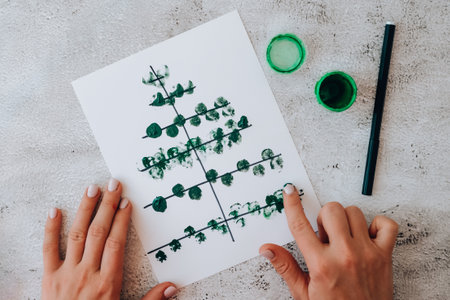 DIY Making greeting card Handmade crafts on holiday for children. Step by step. Do it yourself. Happy New Year xmas tree decoration Paint with fingers Merry Christmas tree. Top view.の写真素材