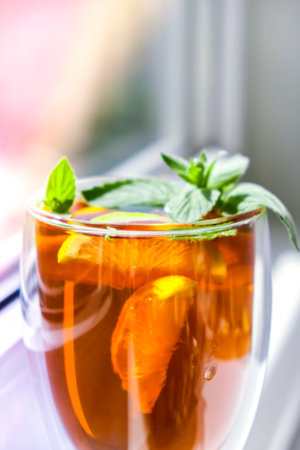 Black and green tea with lemon, cinnamon sticks and mint leaves. Hot drink. Healthy melissa tea natural organic aromatic drink in cup. Summer, Autumn winter warming drink. Stay healthy herbal teaの写真素材