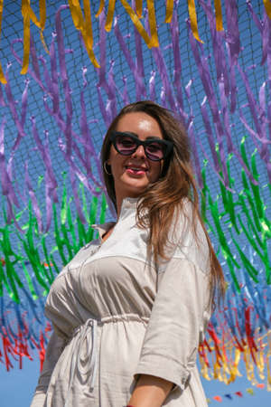 Young woman sitting on festival. Gen z girl enjoying outdoors, expressing positive emotions having...