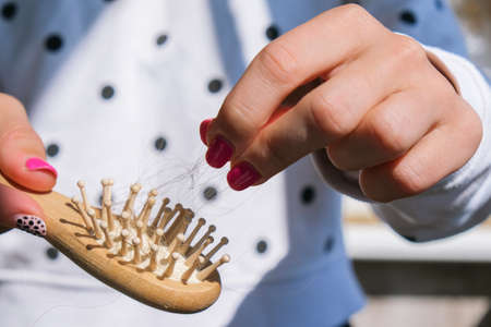 Hair loss on the comb, massage wooden brush with a clump of hair, problem of growth, hair care problems. Hair loss it cause from family history, hormonal changes, unhealthy of aging.の写真素材