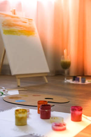 The artists workplace with watercolor paints, gouache, brushes and sheets of paper. Authentic paint brushes still life in art class school as drawing course. Home leisure hobby. Art during staying at homeの写真素材