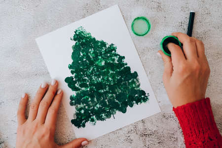 DIY Making greeting card Handmade crafts on holiday for children. Step by step. Do it yourself. Happy New Year xmas tree decoration Paint with fingers Merry Christmas tree. Top view.の写真素材