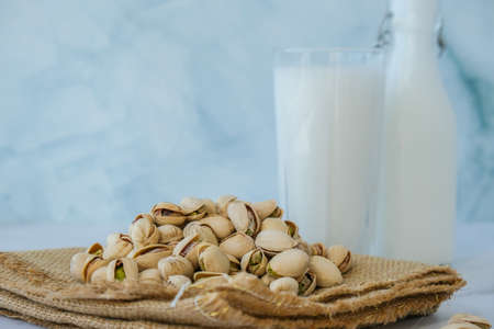 Pistachio lactose free milk for dietary nutrition. Alternative food and vegetarianism. Glass of healthy pistachio milk stands on concrete background. Diet milk, vegetarian food. Gluten free. Nut non-dairy milkの写真素材