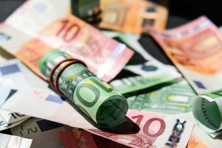 Close up of Euro money roll. Euro banknote set cash money - EU currency. Rolled with rubber euro notes. Business budget of wealth and prosperity finance. Banknotes stacked on each other in different positions.の写真素材