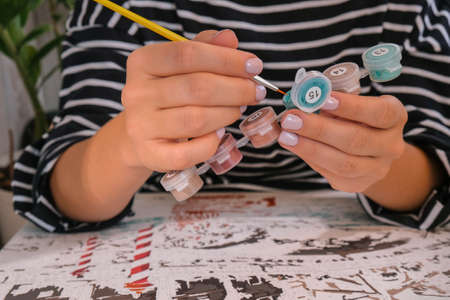 Female hands coloring canvas Picture by numbers Creative hobby. Painting for beginners. Leisure activity for stay home lockdown, anti-stress idea. Meditation, relax conceptの写真素材