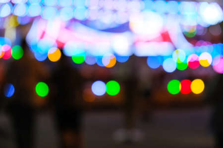 Defocused bright lights flash at a fun carnival at night. Amusement Park Bokeh Lights at Night. Nightlife entertainment backgroundの写真素材