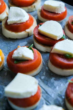 Big red tomatoes with green basil leaves and mozzarella cheese preparing for baking. Healthy homemade food. Cooking. Vegetarian Vegan eatingの写真素材
