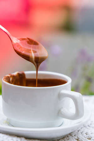 Hot chocolate cup on table at cafe outdoors summer. Coffee time and breakfast in restaurant. Chocolate, hot frothed milk, cocoa. Street cafe. Milk dark chocolateの写真素材