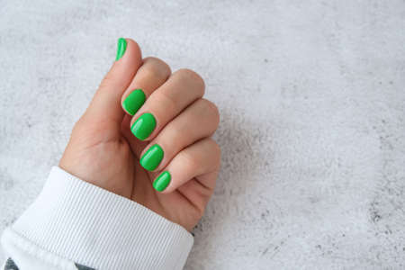 Manicured female hands with stylish green nails. Trendy modern design manicure. Gel nails. Skin care. Beauty treatment. Nail care. Trendy colorsの写真素材