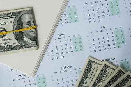 Office workplace desk with dollars and calendar. Counting money for salary. Investment savings....
