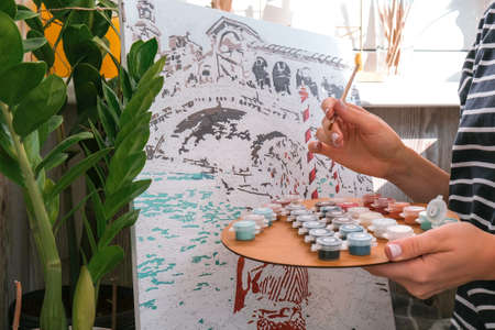 Female hands coloring canvas Picture by numbers Creative hobby. Painting for beginners. Leisure activity for stay home lockdown, anti-stress idea. Meditation, relax conceptの写真素材