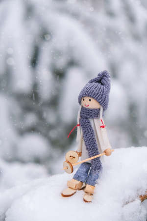 Angel gnome in scarf and knitted hat skiing on snowy fir branch Elf toy on skis in snowy landscape Copy space for text. New year and Merry christmas greeting card background. Winter Holidays resort advertisementの写真素材