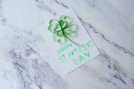 Diy St. Patricks Day greeting card made of Quilling and paper clovers on white background. Gift idea, decor Spring, happy Patrick Day. Step by step.の写真素材