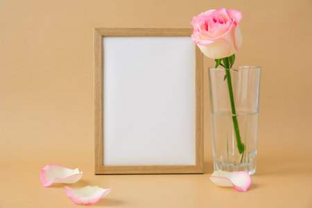 Mockup Wooden frame with Empty white paper blank and delicate pink roses on beige background....