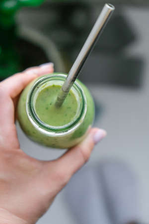 Young millenial blond woman drinking vegan smoothie drink detox. Woman doing yoga exercises at home....